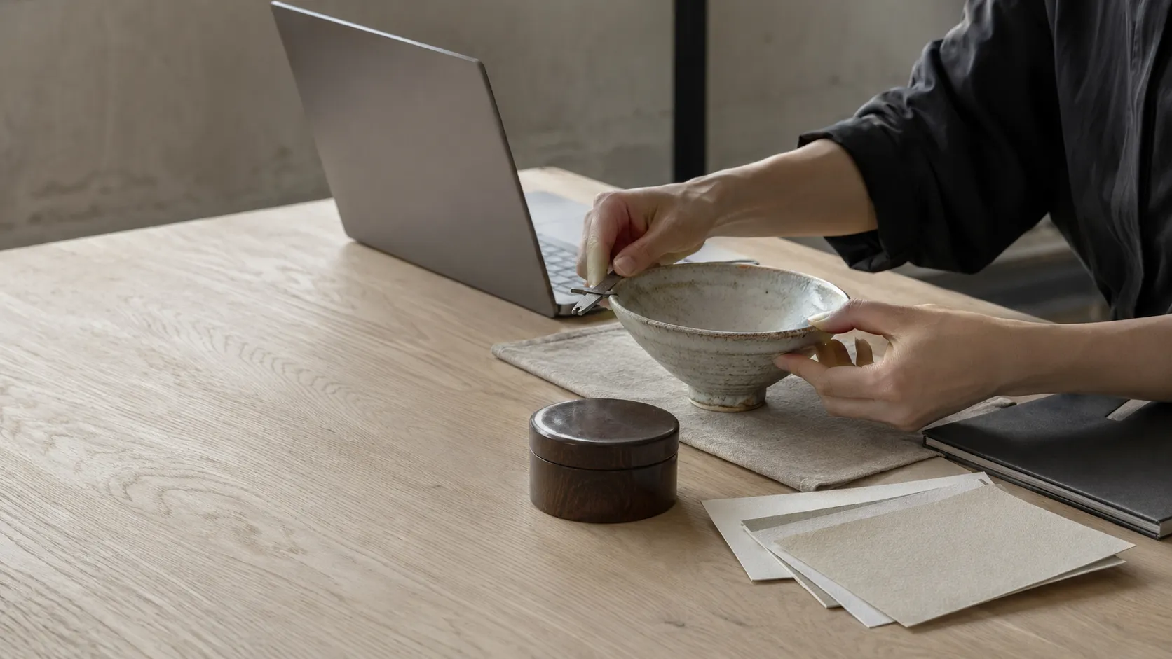 工芸品の寸法や素材を確認し商品情報を編集する様子