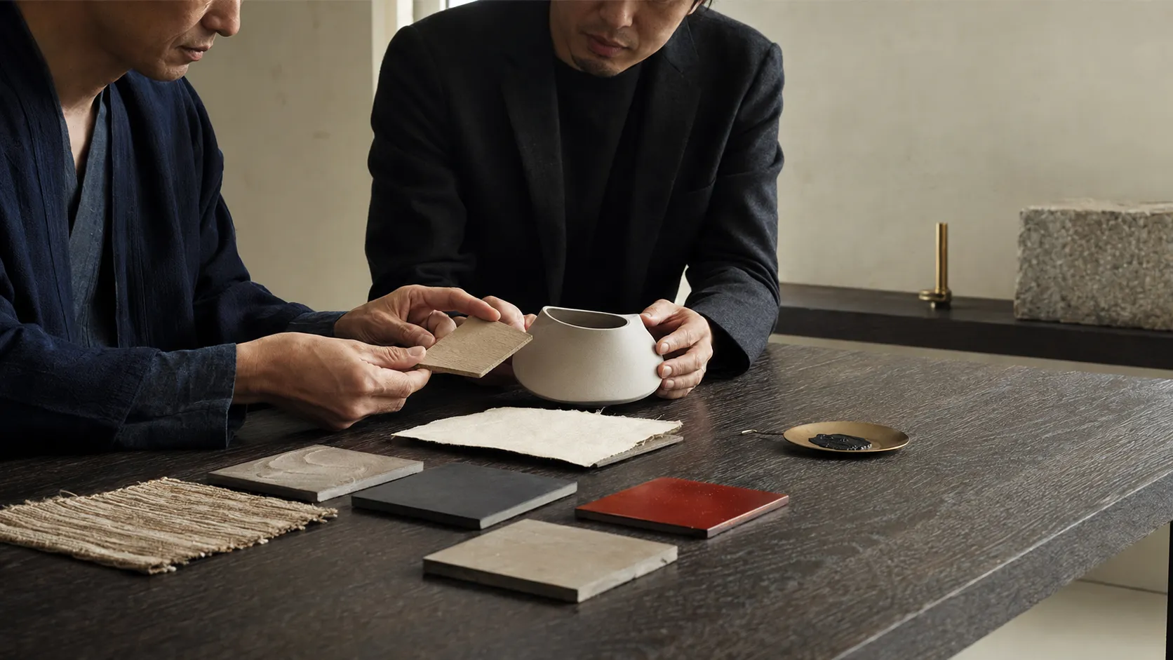 工芸の素材見本と試作品を確認する企業担当者と作家