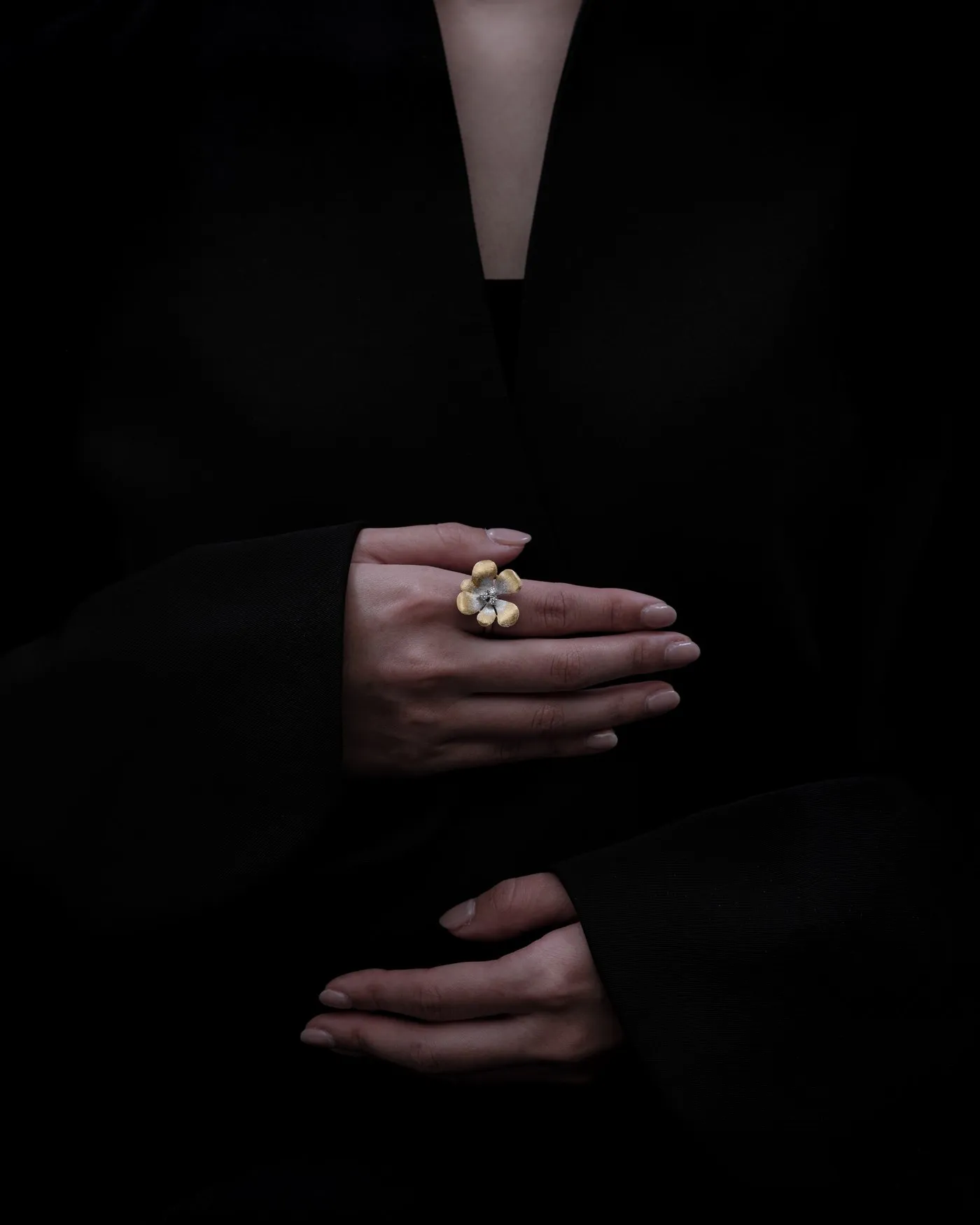 ARCELF’s flower-inspired ring worn against a black outfit