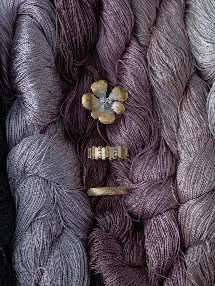 ARCELF jewelry arranged on purple and gray bundles of silk thread