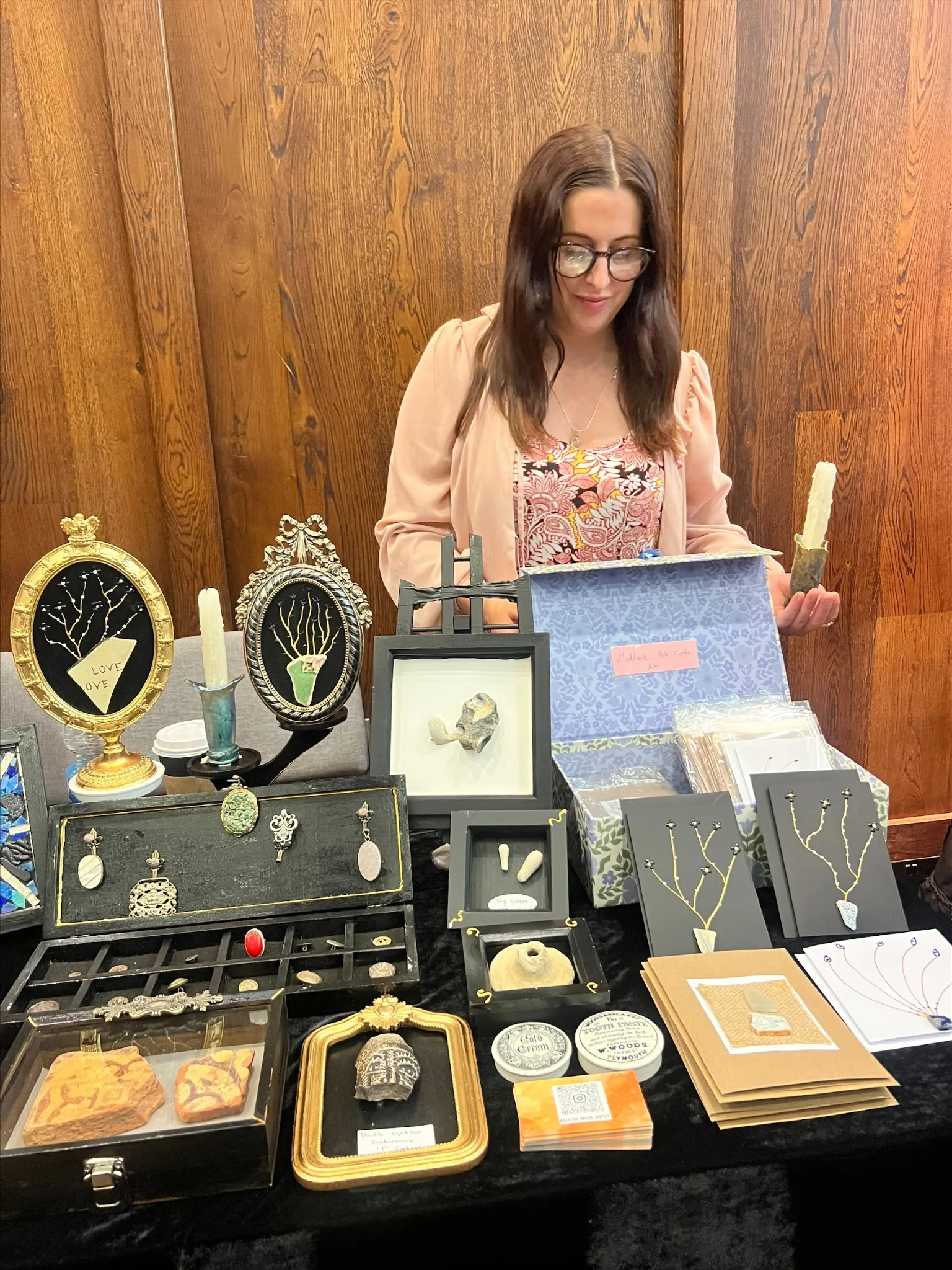 Nagat Elizabeth standing behind a table displaying her work