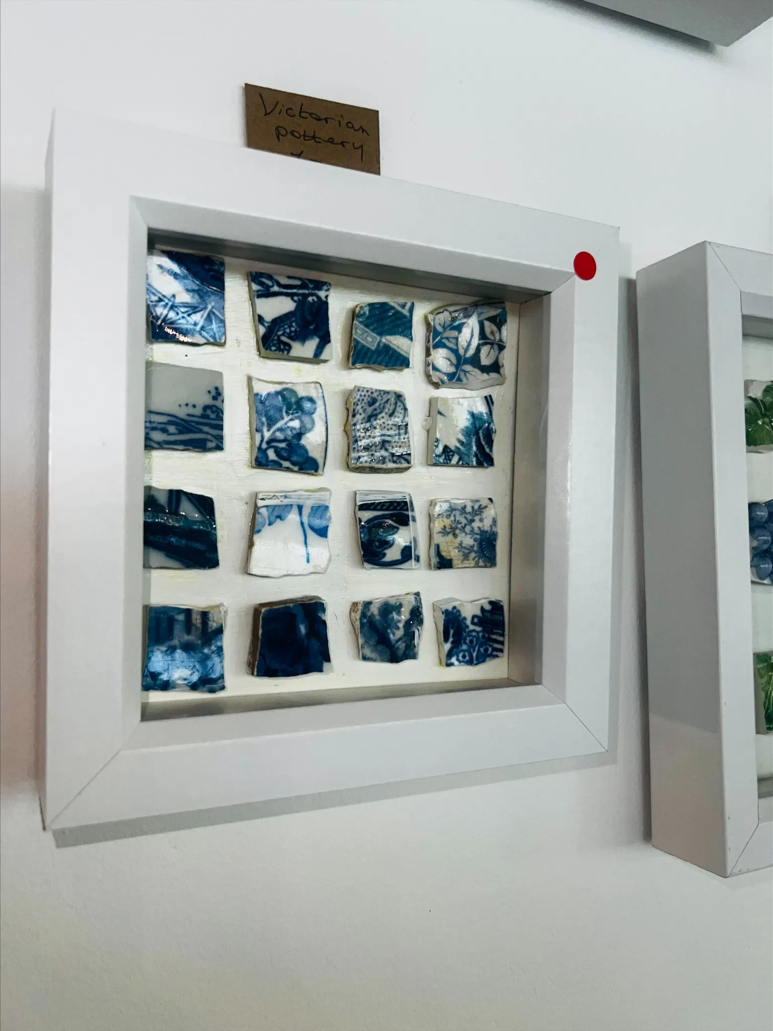 Framed arrangement of blue-and-white pottery sherds by Nagat Elizabeth